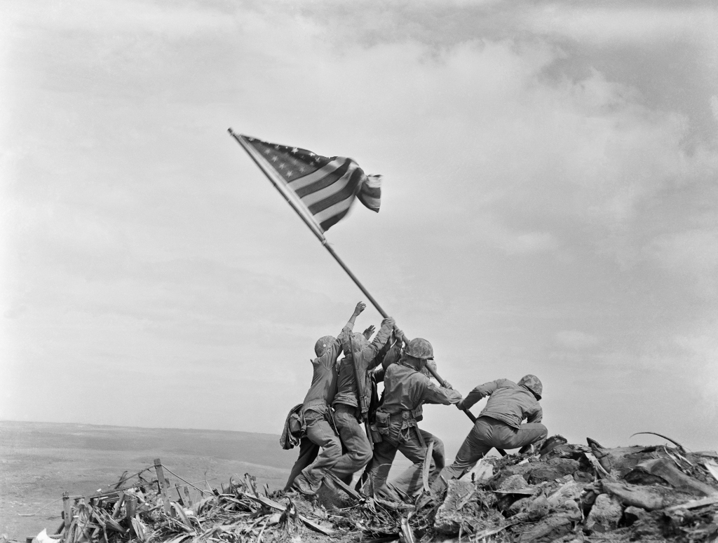 Imagem mostra soldados americanos levantando a bandeira dos EUA em Iwo Jima: ilha foi palco para conflitos com navios e tropas terrestres na Segunda Guerra Mundial