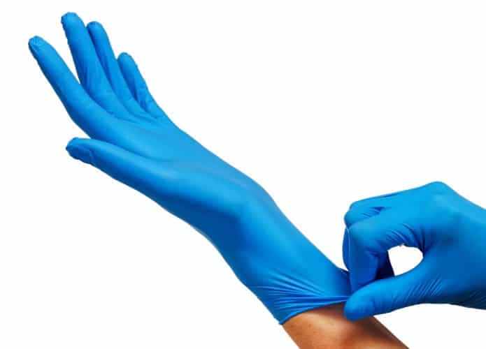 Mãos colocando luvas cirúrgicas