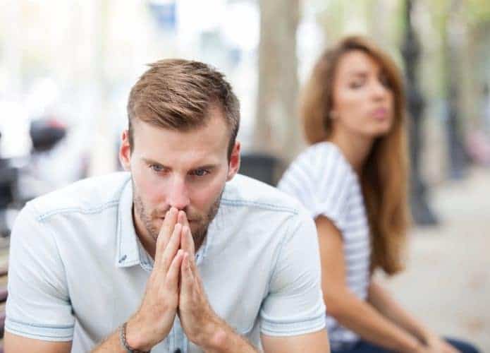 Homem em primeiro plano e mulher desfocada