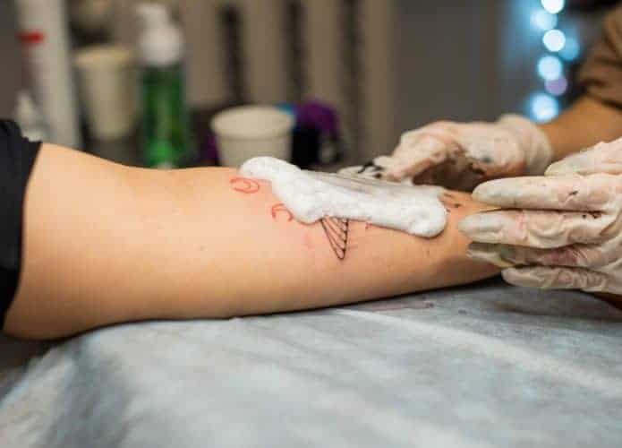 Tatuador lavando tatuagem