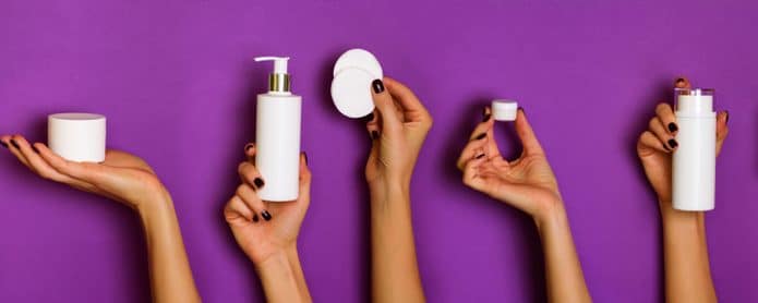 Mãos de mulheres segurando produtos de skin care