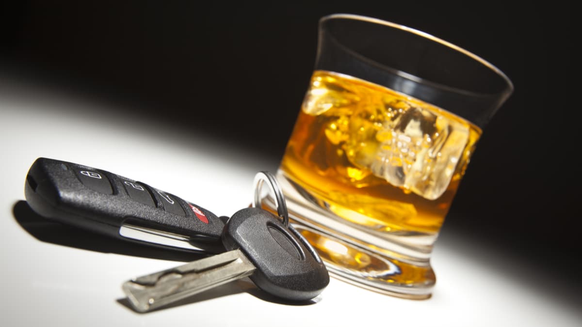 Chave e whisky representando direção alcoolizada