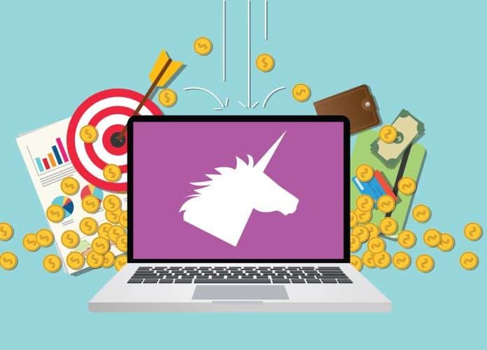 Ilustração de um unicórnio na tela de um computador com moedas ao fundo