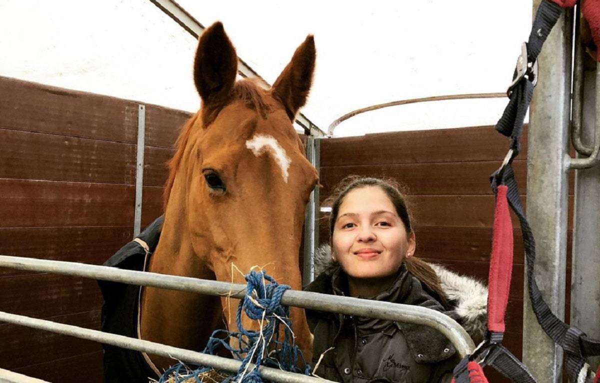 Jovem caucasiana junto com um cavalo
