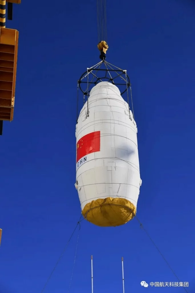 O satélite Ziyuan-1 02E, já posicionado em sua cápsula e sendo içado por guindaste ao topo de um foguete Long March