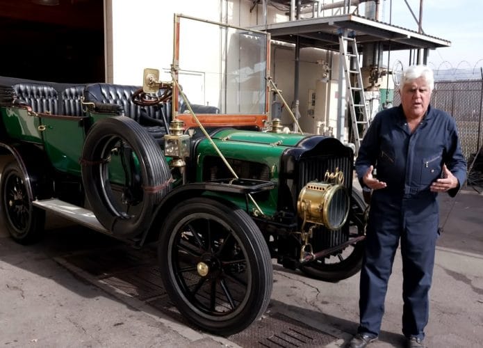 Apresentador Jay Lano ao lado de um carro a vapor