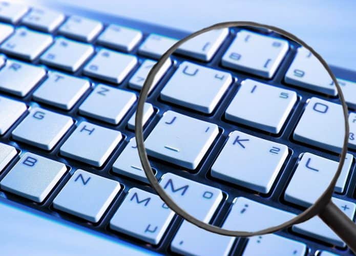 Uma lupa sobre o teclado para ilustrar uma captura de logine e senha do phishing realizado pelos hackers nas platafromas da Meta