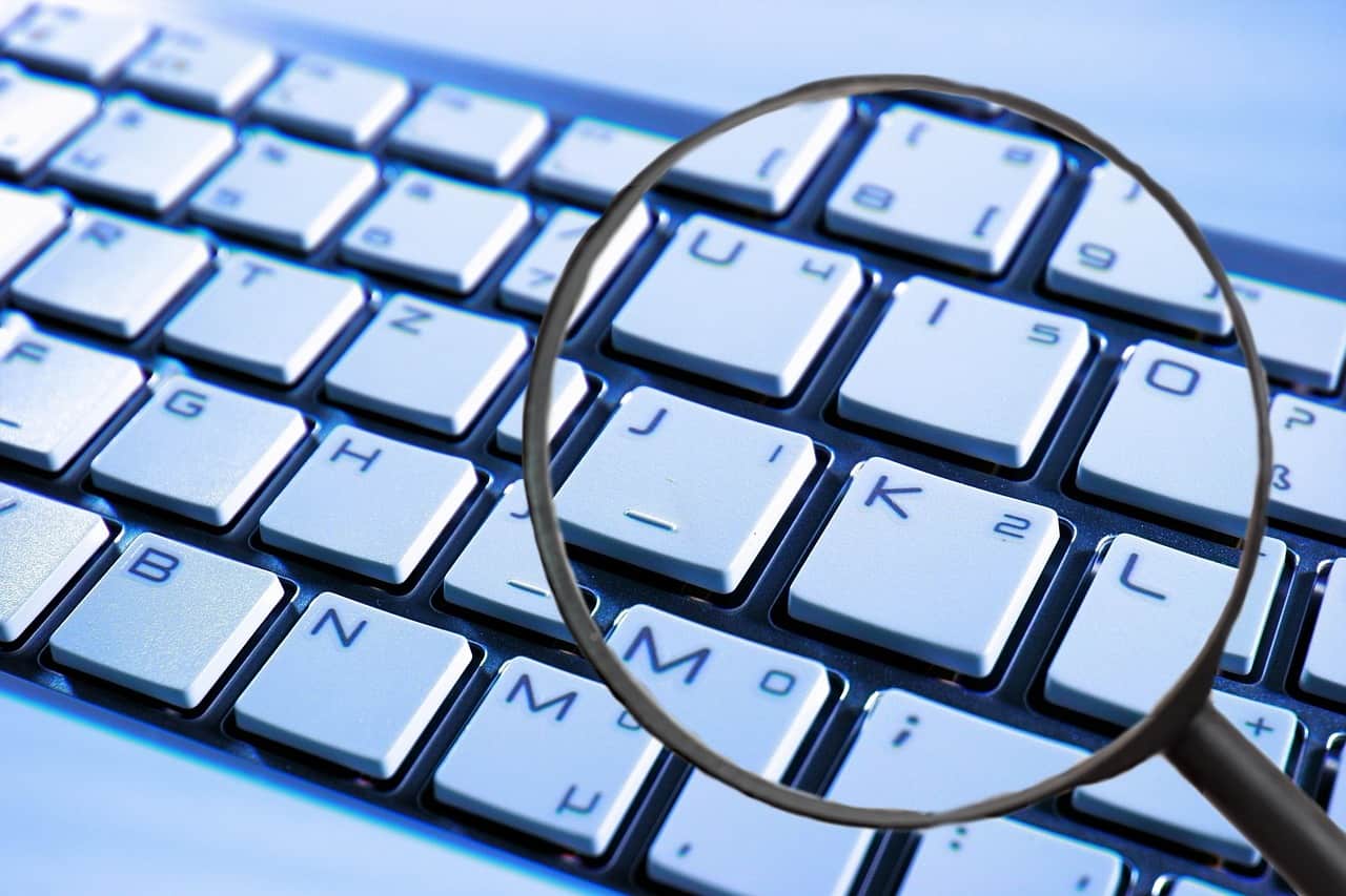 Uma lupa sobre o teclado para ilustrar uma captura de logine e senha do phishing realizado pelos hackers nas platafromas da Meta