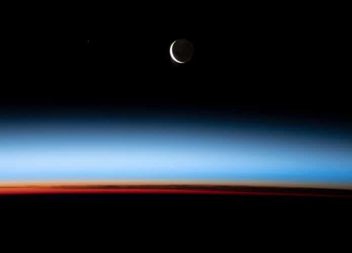 Lua crescente sobre o por do sol na Terra