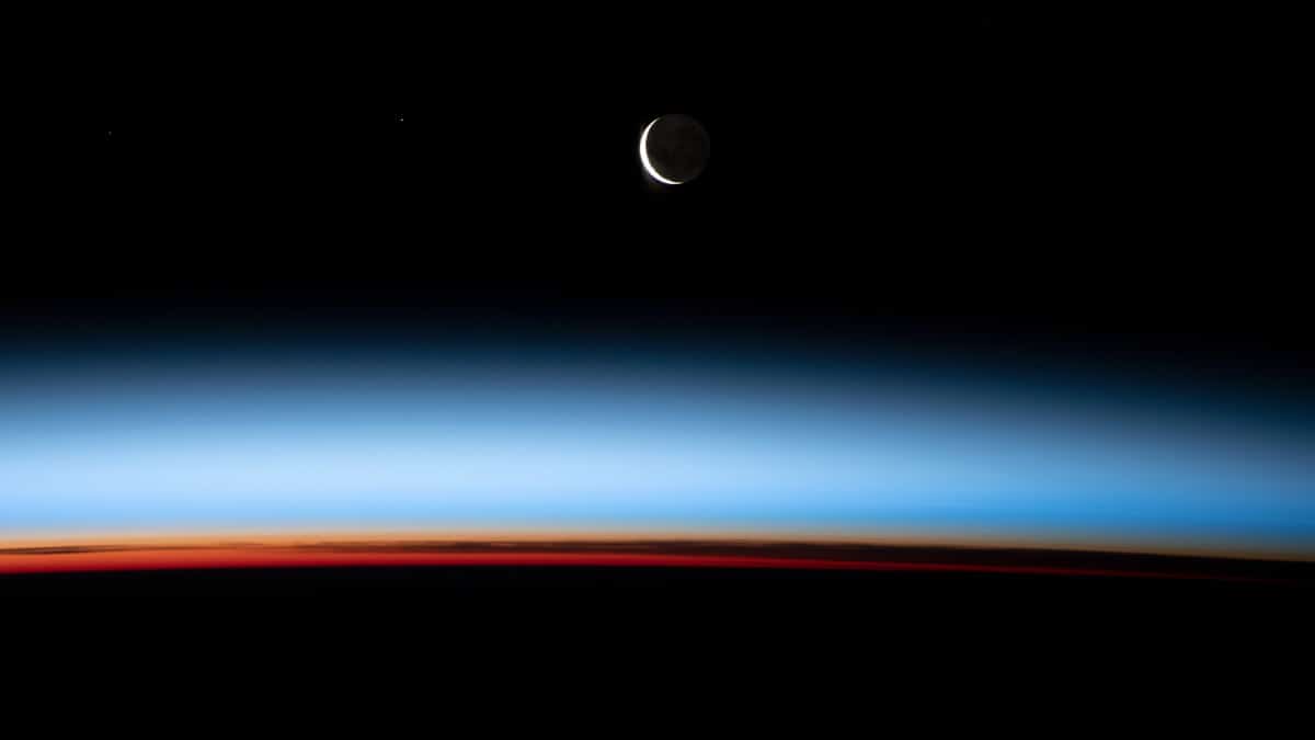 Lua crescente sobre o por do sol na Terra