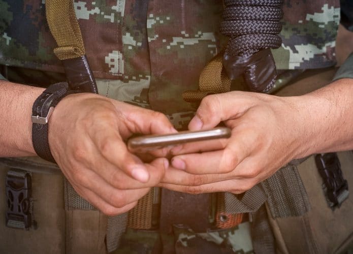 Um militar usando celular para ilustrar que o exército suíço baniu o WhatsApp