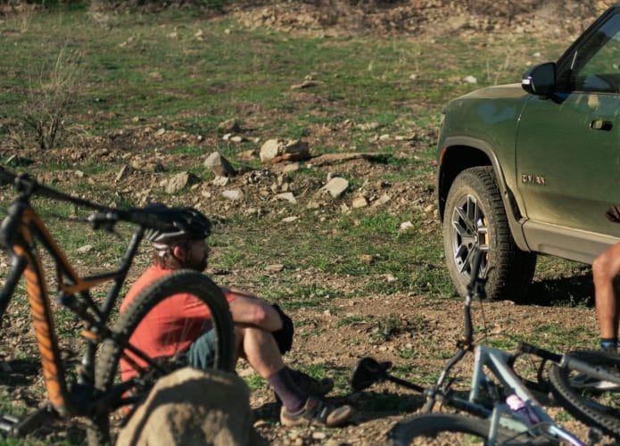 Duas pessoas e uma caminhonete Rivian, além de duas bicicletas