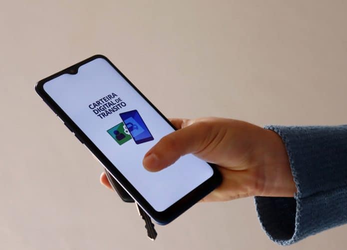 Motorista exibe o aplicativo da Carteira Digital de Trânsito aberto na tela de um celular