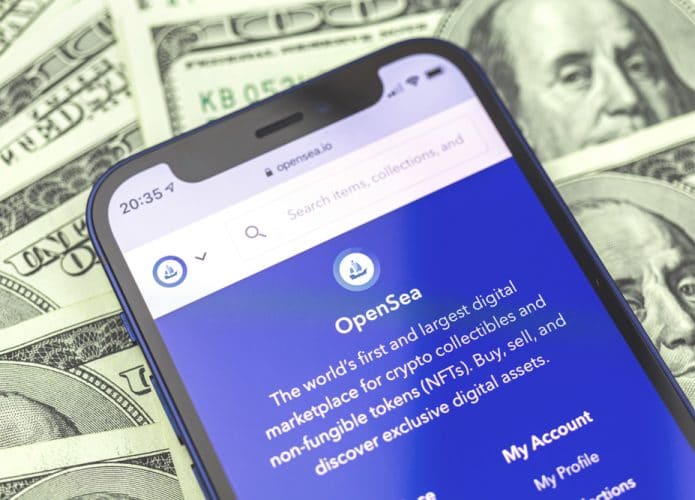 Site da OpenSea, o maior marketplace do mundo, aberto na tela de um celular com notas de dólares ao fundo