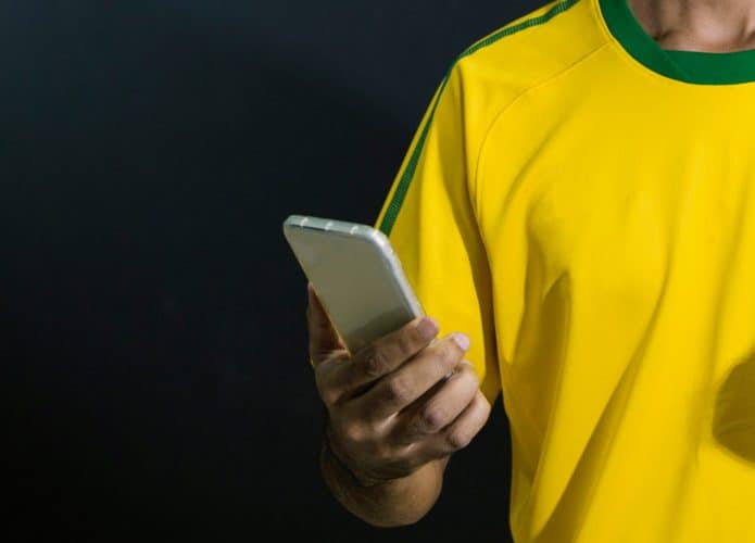 Pessoa usando aplicativo Bolsonaro TV em seu celular e correndo risco de privacidade