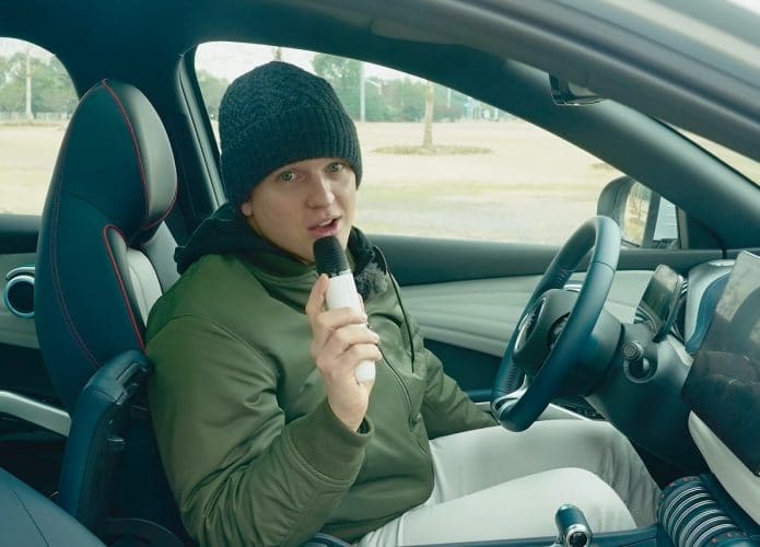 Homem segurando um microfone de karaokê que vem no crossover Yuan Plus, da BYD