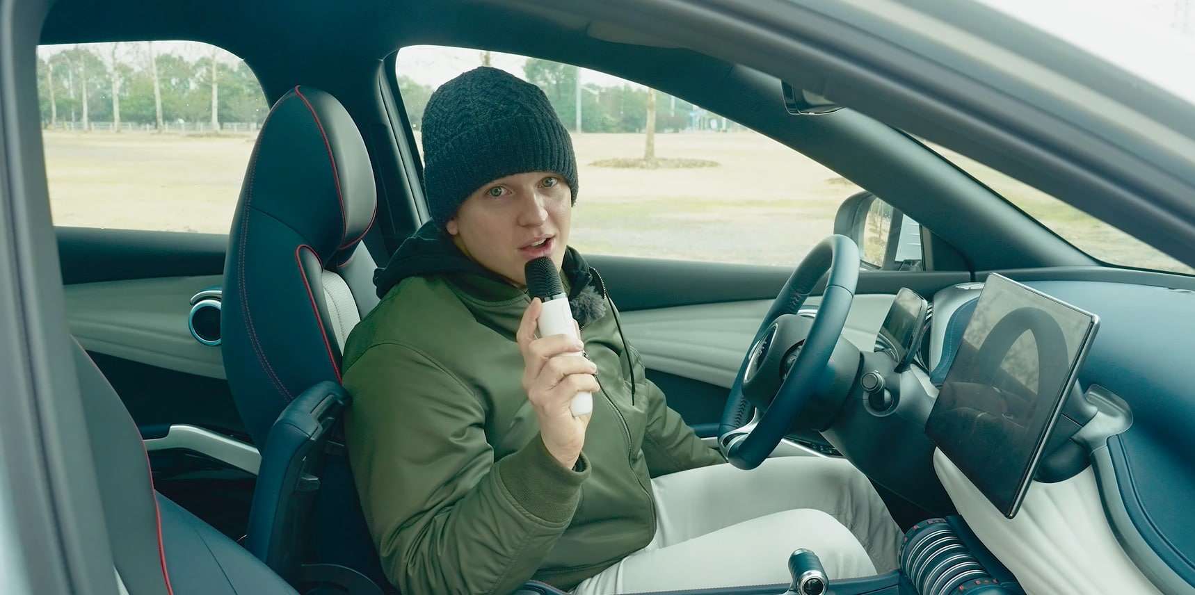 Homem segurando um microfone de karaokê que vem no crossover Yuan Plus, da BYD