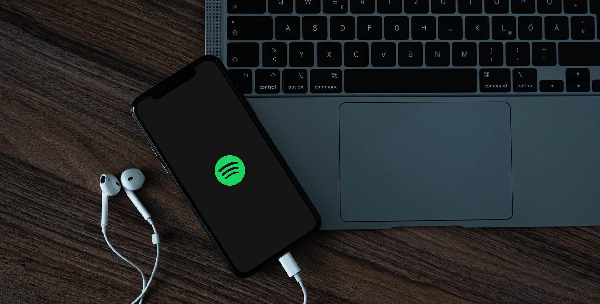 Um notebook e um celular com o app Spotify aberto na tela
