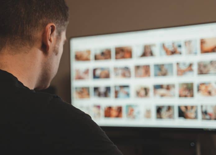 Homem olhando imagens pornográficas na tela do computador