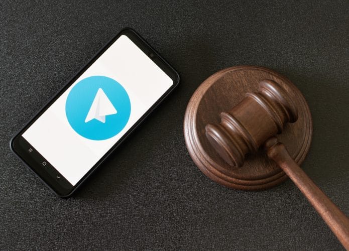 Aplicativo Telegram na tela do smartphone e martelo de um juiz