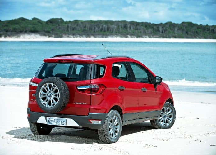 EcoSport na cor vermelha em uma praia, de frente para o mar. Veículo sai de linha na Europa e no mundo