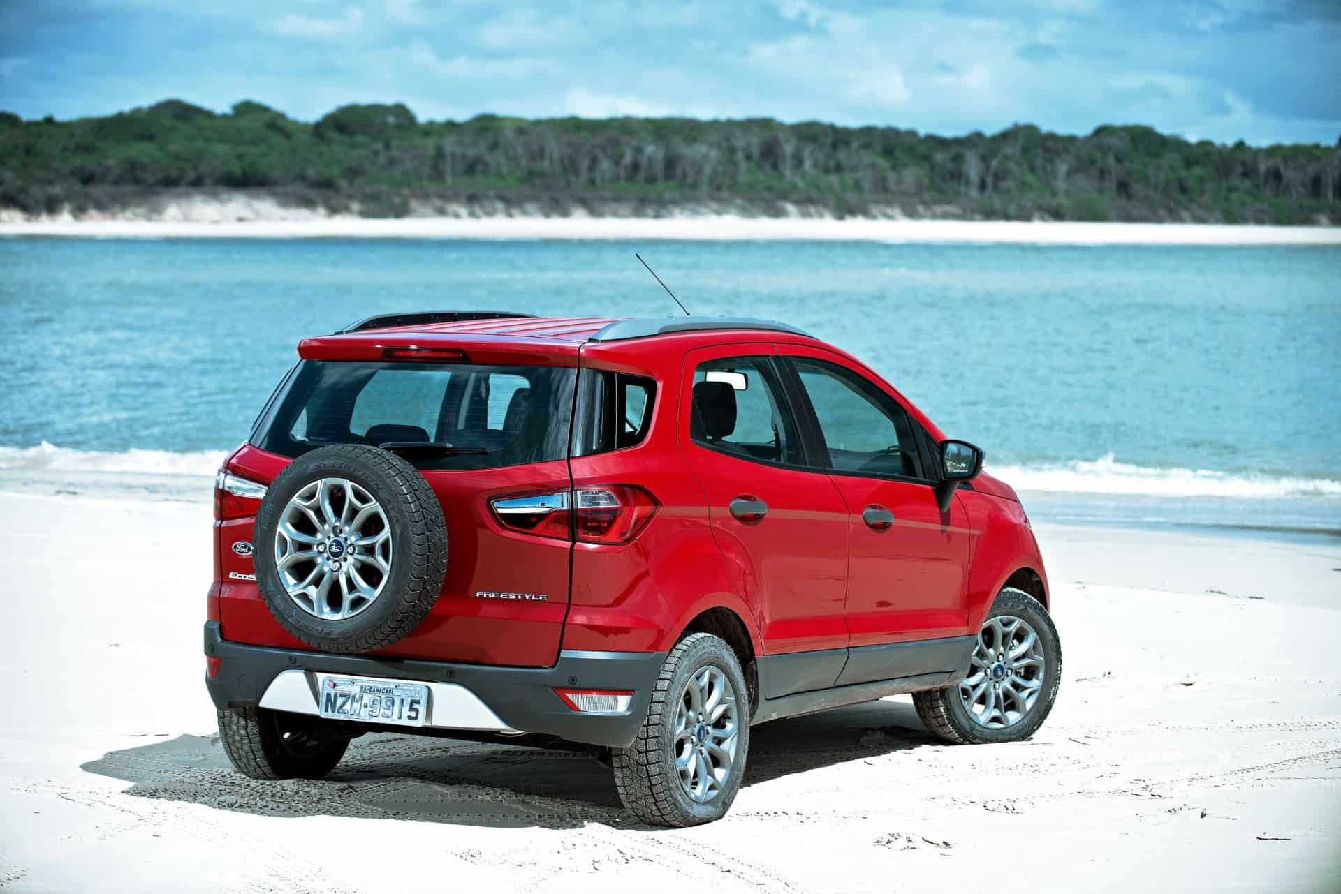 EcoSport na cor vermelha em uma praia, de frente para o mar. Veículo sai de linha na Europa e no mundo