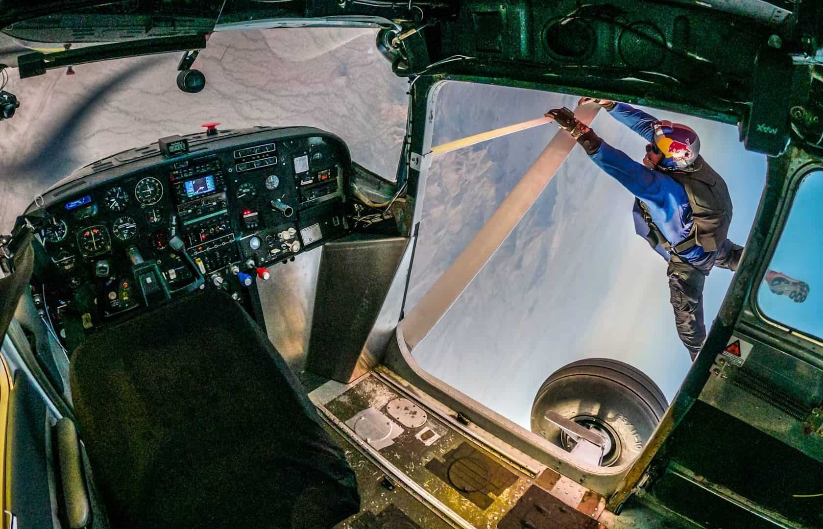Piloto na asa do avião para trocar em evento da Red Bull