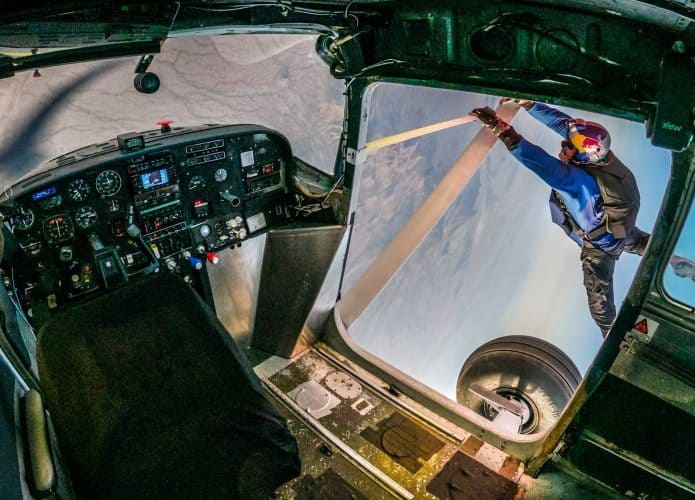 Piloto na asa do avião para trocar em evento da Red Bull