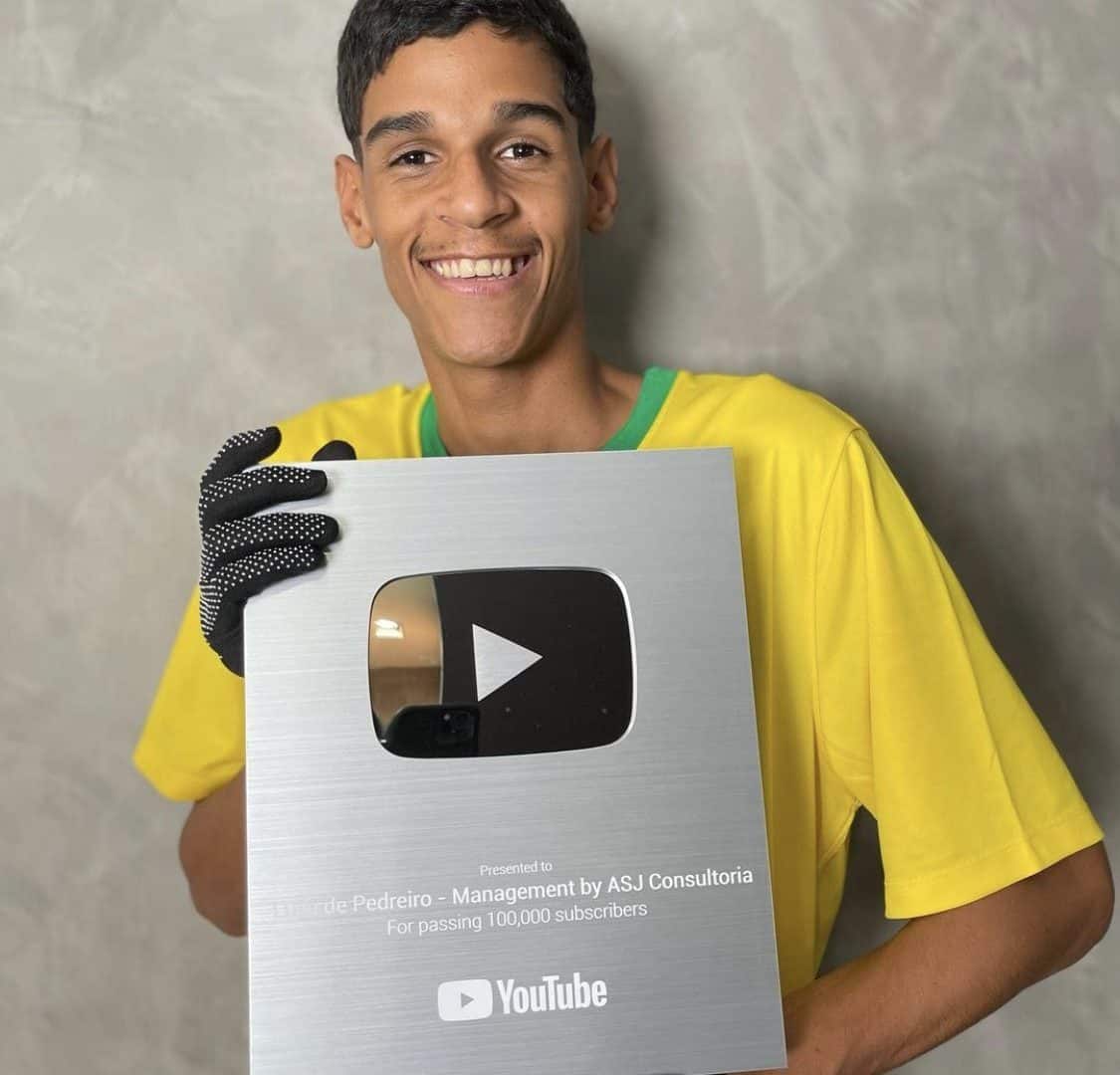 Luva de Pedreiro segurando sua placa de 100 mil inscritos