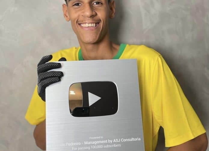Luva de Pedreiro segurando sua placa de 100 mil inscritos
