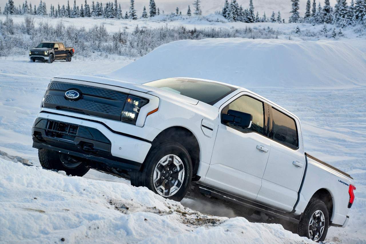 F-150 Lightning na cor branca subindo um monte coberto de neve