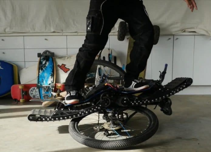 Skate elétrico com rodas de tanque com uma bicicleta como obstáculo