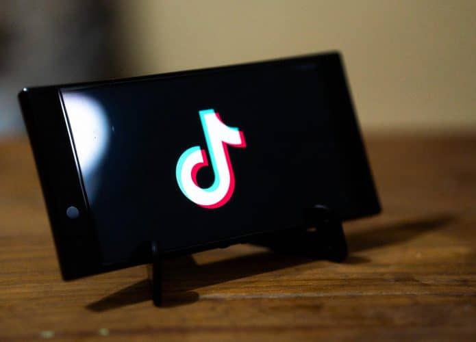Celular com aplicativo TikTok na tela, para ilustrar os processos movidos contra a empresa por causa do desafio do apagão