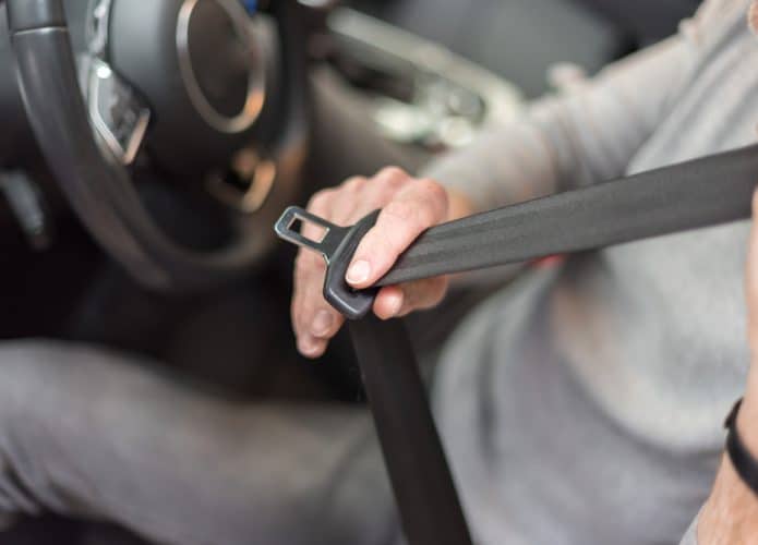 Motorista colocando o cinto de segurança em um carro
