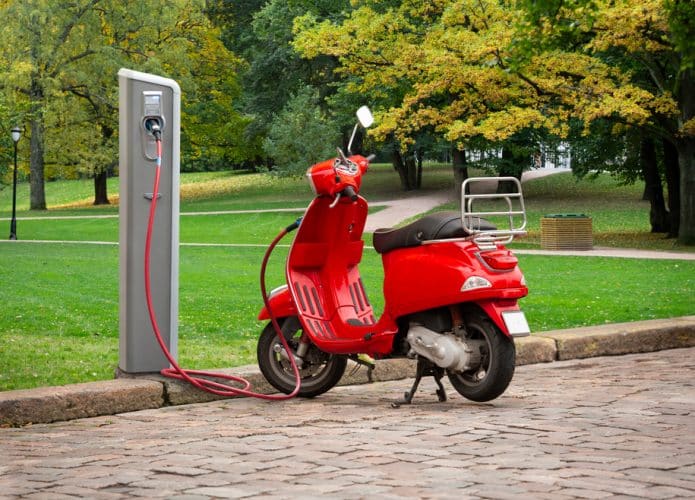 Scooter elétrica carregando em uma estação.