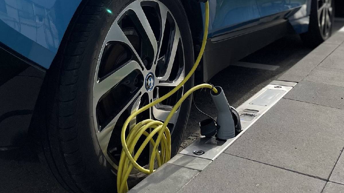 Um carregador para carros elétricos que fica no meio-fio da calçada
