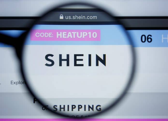 Homepage da Shein aberta em computador com lupa em cima