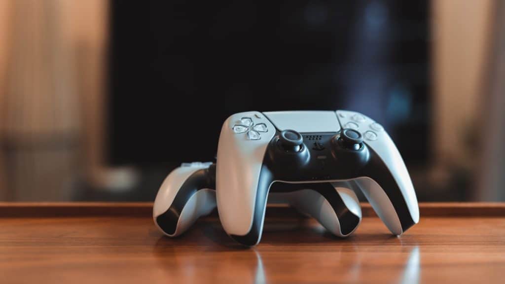 Dois controladores de PlayStation 5 (PS5) na mesa.