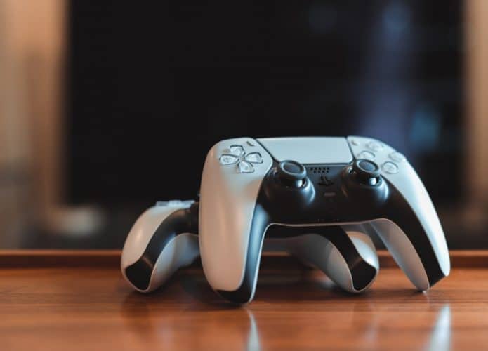 Dois controladores de PlayStation 5 (PS5) na mesa.