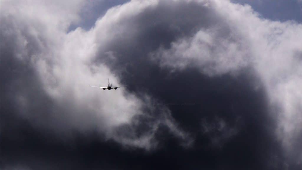 Avião no céu prestes a entrar numa nuvem de tempestade