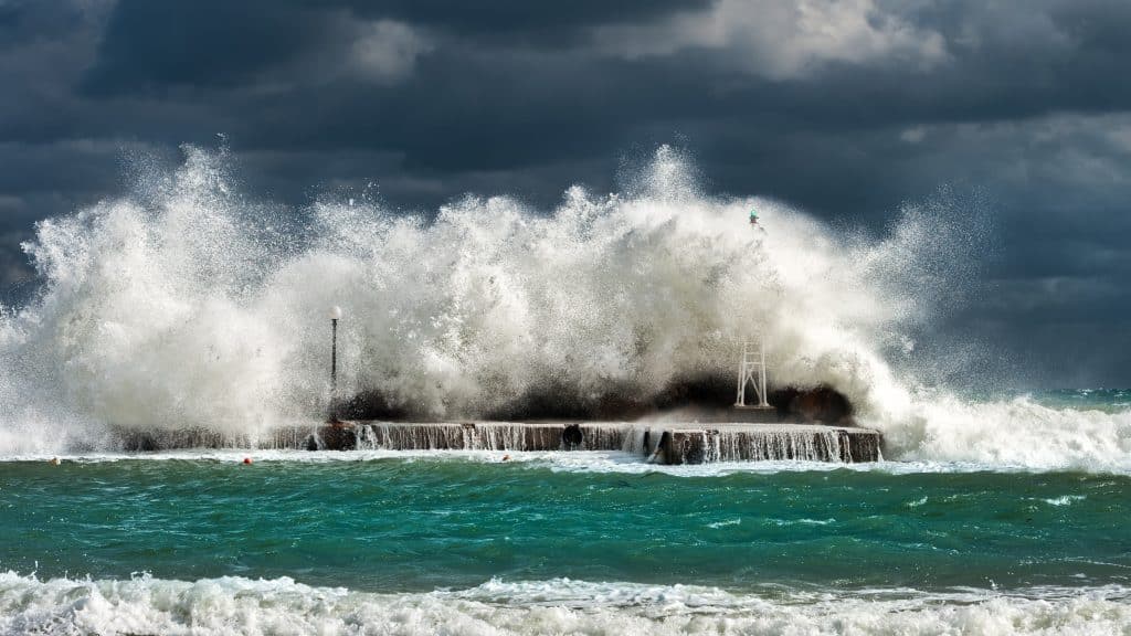 Onda encobrindo prédios de farol em ilha