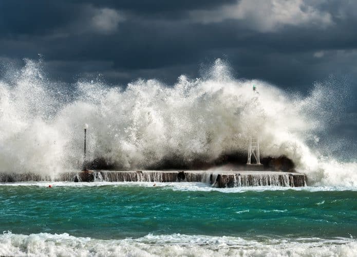 Onda encobrindo prédios de farol em ilha