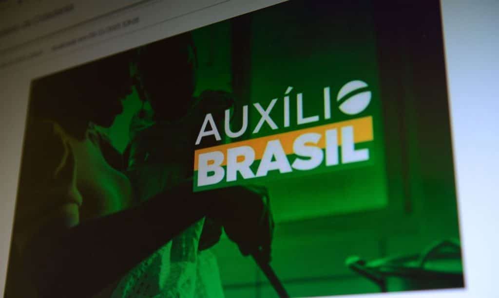 Computador com imagem do Auxílio Brasil na tela