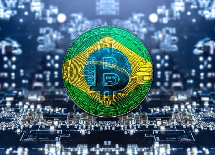 Moeda de Bitcoin cercada de linhas de ações financeiras e sobreposta pela bandeira do Brasil