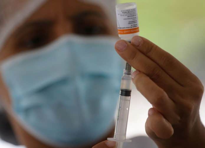 Enfermeira carregando seringa com dose da vacina contra Covid