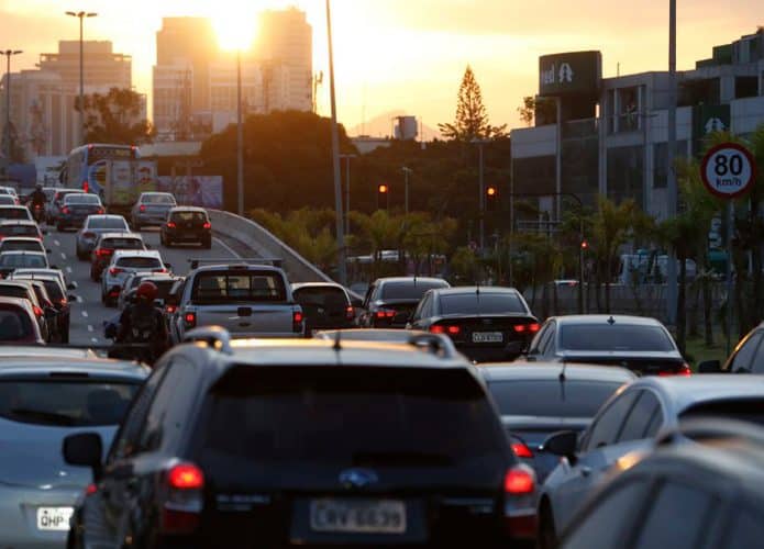 Carros em avenida durante pôr-do-sol
