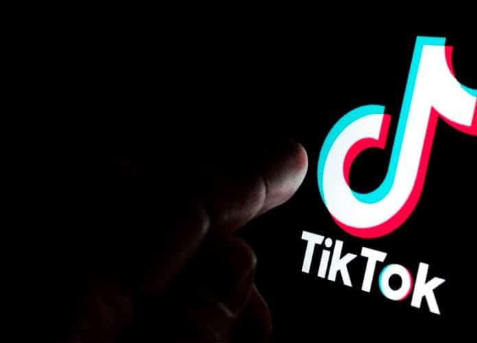 Pessoa acessando TikTok no celular no escuro