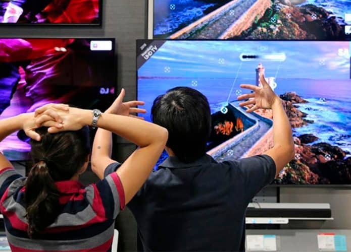 Duas pessoas analisando TV para comprar