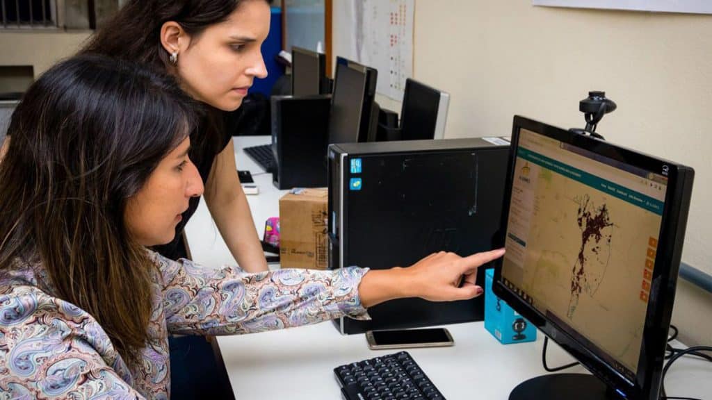 Pesquisadora da UFRJ mostrando como plataforma Alarmes funciona