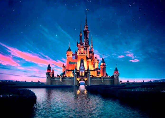 Cena da vinheta da Disney, com castelo ao fundo, debaixo de céu noturno colorido